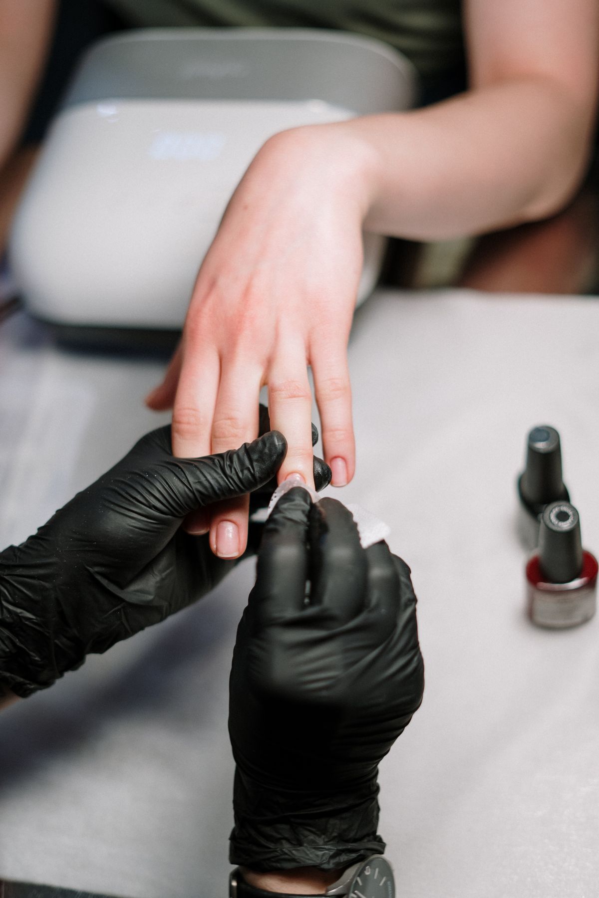 Nail technician applying polish at Nail Therapy Beauty Boutique